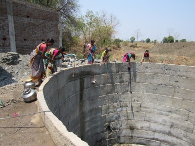 women drawing water from common well at manyali.JPG